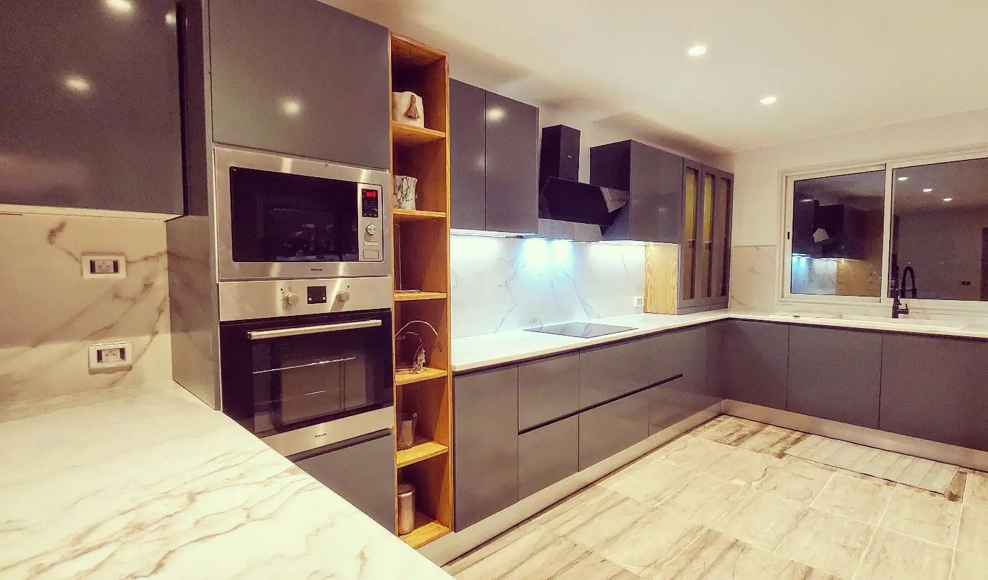 Cuisine moderne gris anthracite avec plan de travail en marbre et étagères en bois